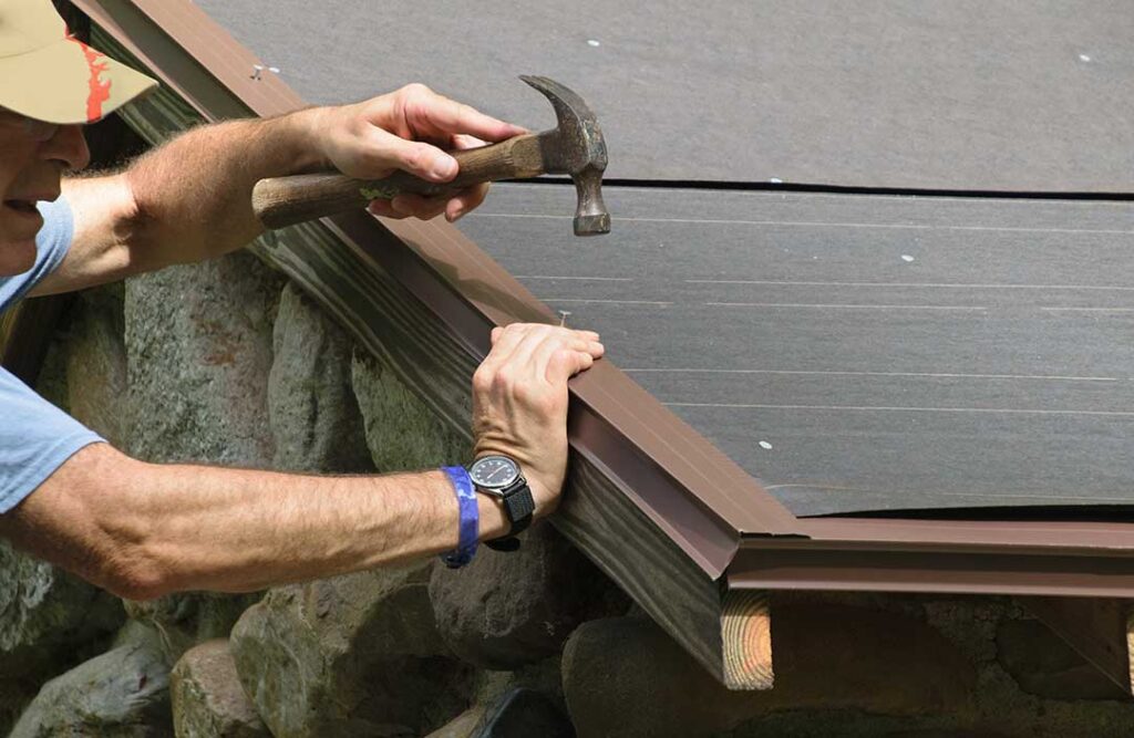 A child’s baseball rests beside cracked roof shingles near a suburban home after an impact.